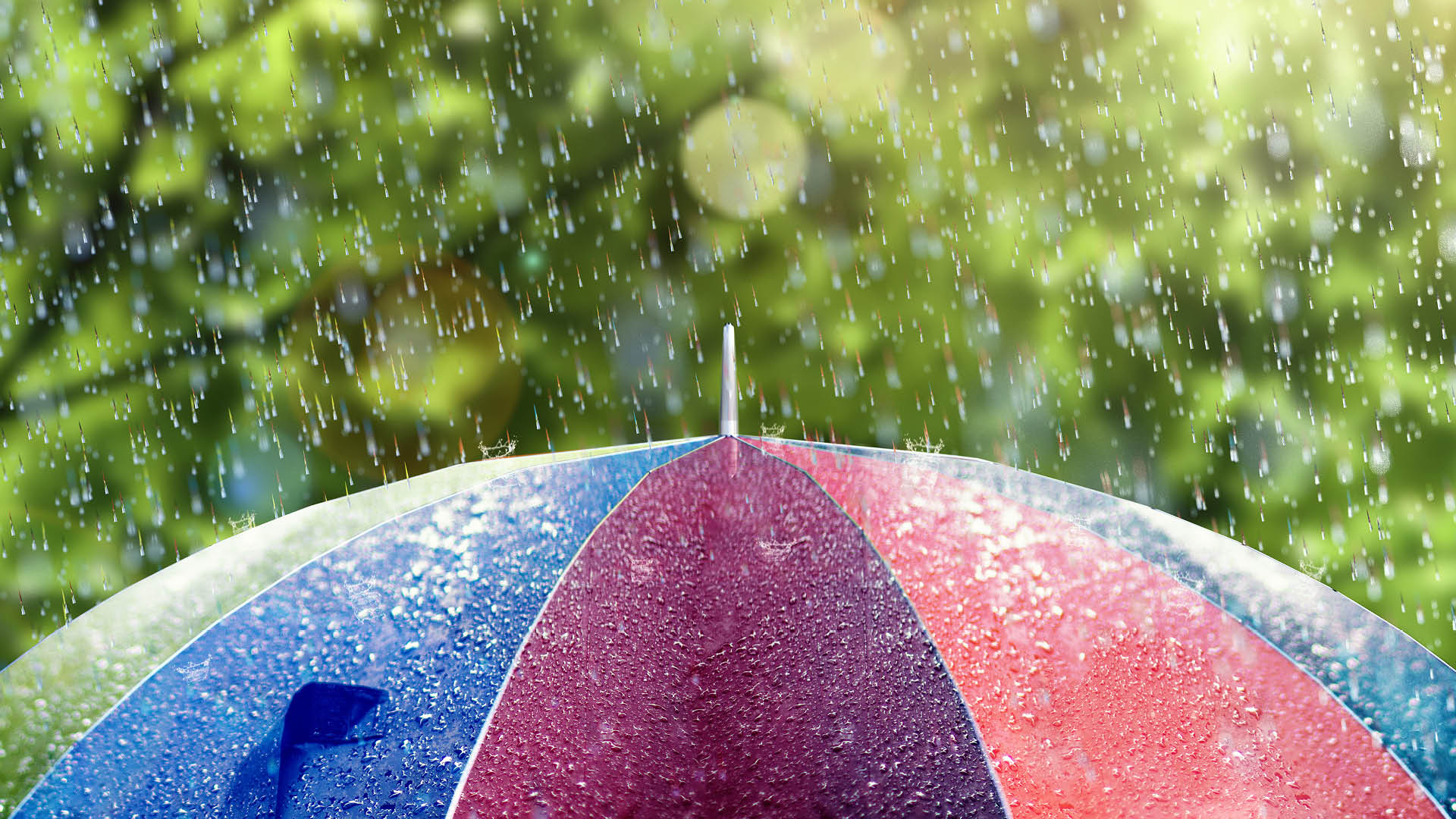 värikkään sateenvarjon päälle sataa vettä