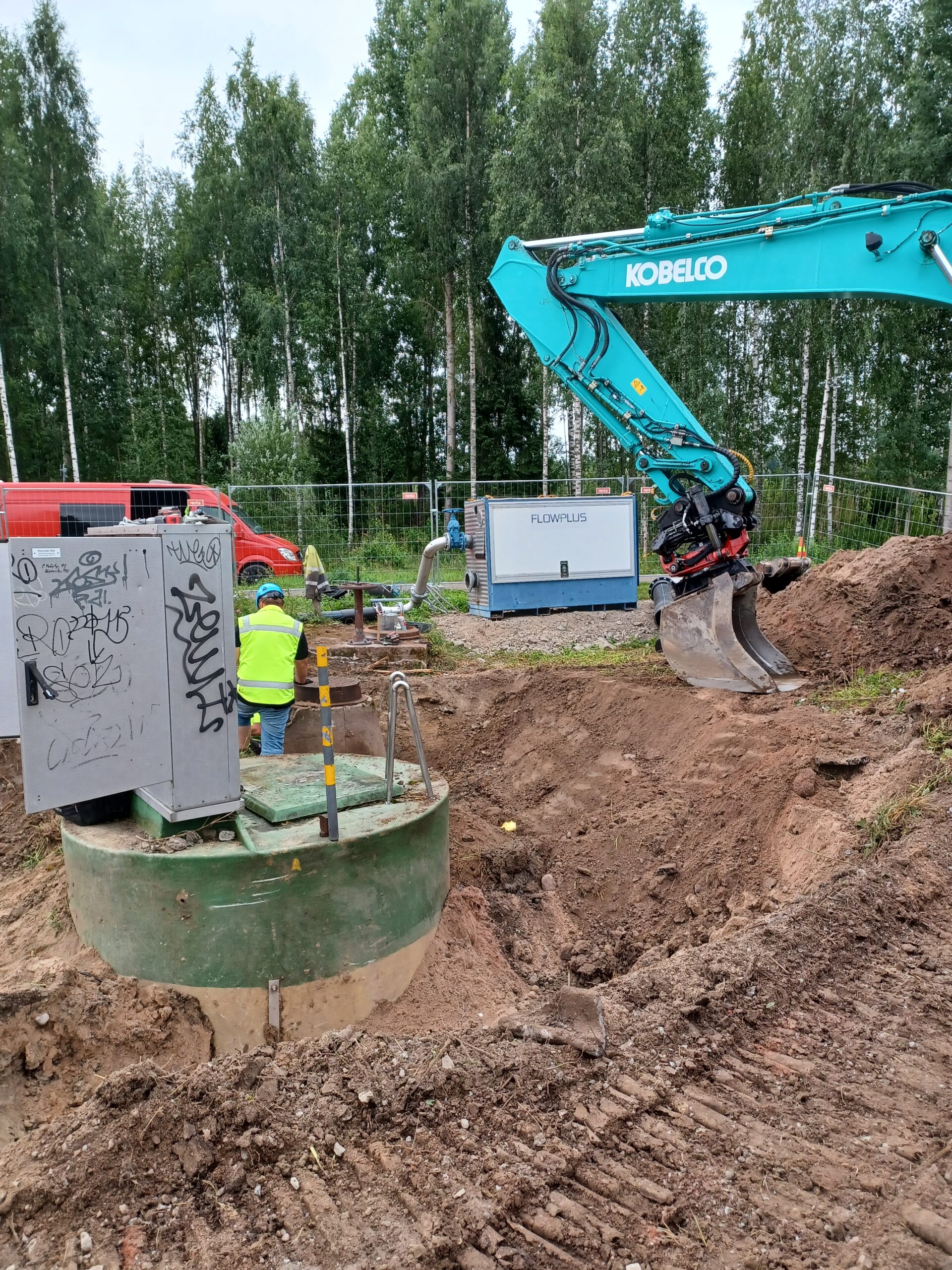 Kaivinkone ja henkilö jätevesipumppaamon saneeraustyömaalla